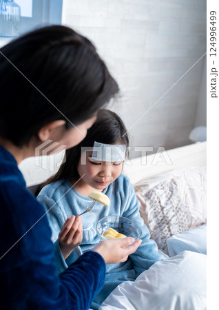 ベッドで看病される女の子 124996499