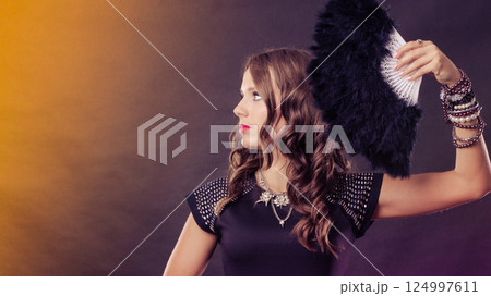 beautiful brunette woman with black fan in hand beautiful brunette woman with black fan in hand 124997611