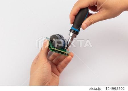 Hands of a master holding an electronic board on a Hands of a master holding an electronic board on a 124998202