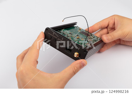 Hands of a master holding an electronic board on a Hands of a master holding an electronic board on a 124998216