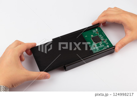 Hands of a master holding an electronic board on a Hands of a master holding an electronic board on a 124998217