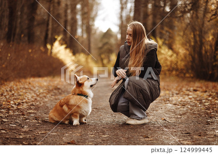 Woman with Corgi in Autumn Park 124999445