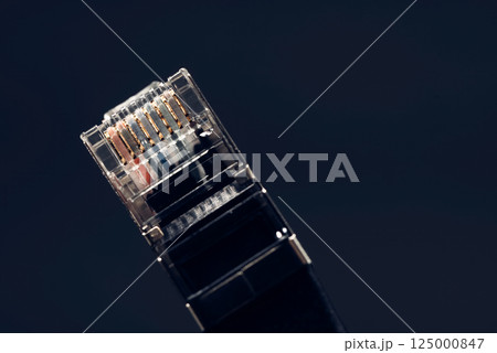 Close-up of a network cable connector highlighting its gold contacts, symbolizing internet connectivity and data transfer Close-up of a network cable connector highlighting its gold contacts, symbolizing internet connectivity and data transfer 125000847