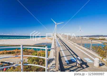 掛川市にある青空に映える国安海岸と潮騒橋と風力発電の風景(静岡県) 掛川市にある青空に映える国安海岸と潮騒橋と風力発電の風景(静岡県) 125000997
