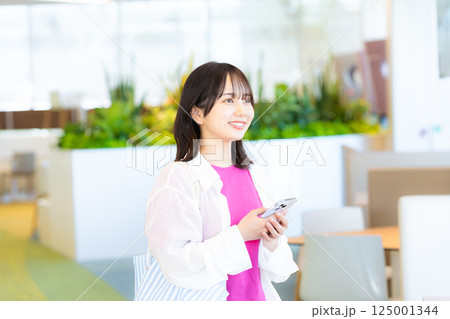 スマホを見る笑顔の女性 スマホを見る笑顔の女性 125001344