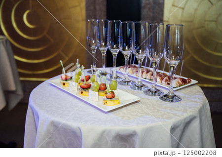 Appetizer Plate. An area for welcoming guests with food and empty champagne glasses Appetizer Plate. An area for welcoming guests with food and empty champagne glasses 125002208