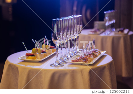 Appetizer Plate. An area for welcoming guests with food and empty champagne glasses Appetizer Plate. An area for welcoming guests with food and empty champagne glasses 125002212