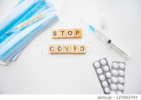 Stop coronavirus inscription. Preparation for vaccination against covid-19. Syringe, vaccine, pills, medical mask. Stop coronavirus inscription. Preparation for vaccination against covid-19. Syringe, vaccine, pills, medical mask. 125002343
