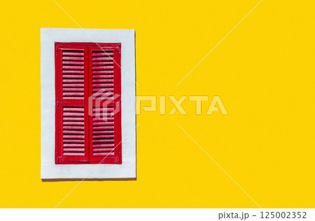 Minimalist style photo of yellow wall with red window in white frame, Murano, Venice, Italy 125002352