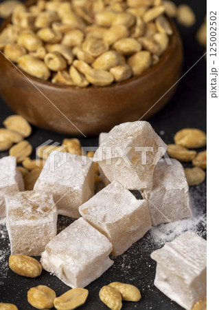 Turkish delight with peanuts, scattered oriental sweets Turkish delight with peanuts on a board 125002502