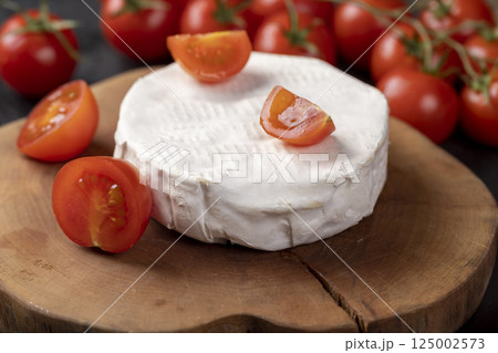 soft cheese with mold and ripe small red tomatoes 125002573