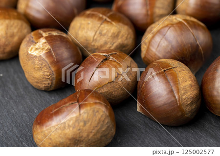cutting the shells of edible chestnut nuts for baking 125002577