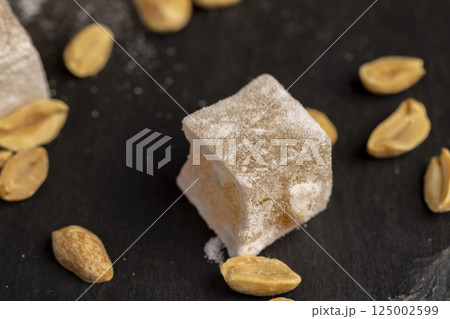 Turkish delight cubes and toasted peanuts on a slate surface, top view Turkish delight cubes and toasted peanuts on a slate surface, top view 125002599