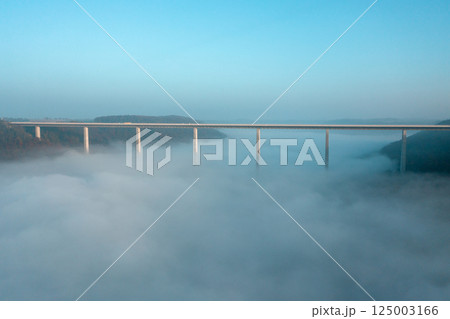 Germany's tallest bridge over dense fog, drone aerial view, at sunrise in Braunsbach, Germany 125003166