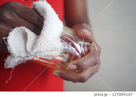 Cleaning a glass object with a cloth in a bright setting 125004187