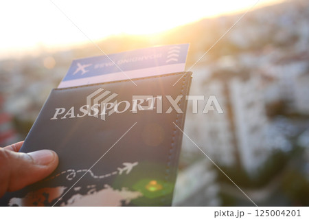Planning a trip with a passport and boarding pass at sunset Planning a trip with a passport and boarding pass at sunset 125004201