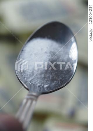 Silver spoon filled with sugar substitute , sweetener sugar 125004234