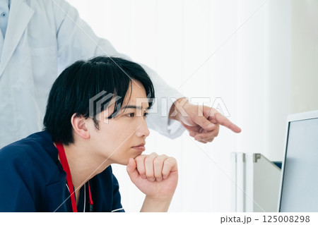 データを見て話し合う男性医師たち 125008298