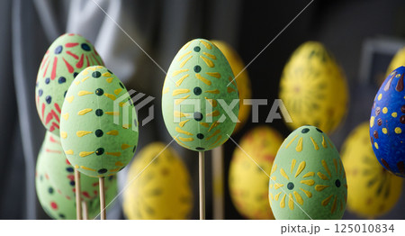 Close-up shot of colorful decorated Easter eggs displayed on wooden sticks. Close-up shot of colorful decorated Easter eggs displayed on wooden sticks. 125010834