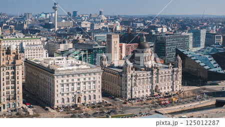 Aerial view of Liverpool showcasing the Three Graces, Radio City Tower, and Museum of Liverpool along the waterfront under clear weather. 125012287