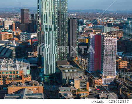 Aerial view of Manchester, UK, showcasing a glass skyscraper, high rise buildings, the Manchester Central Convention Complex, and distant hills. Aerial view of Manchester, UK, showcasing a glass skyscraper, high rise buildings, the Manchester Central Convention Complex, and distant hills. 125012527