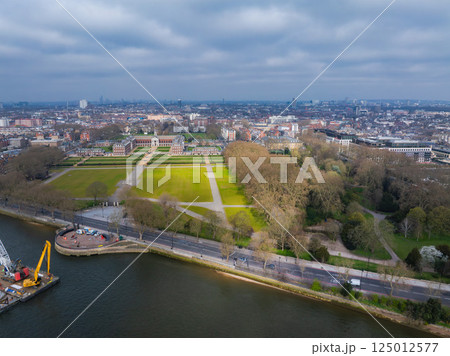 Aerial view of Greenwich in London featuring Greenwich Park, the Old Royal Naval College, the River Thames, and urban development under a cloudy sky. 125012577