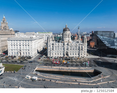 Aerial view of Liverpool showcasing the Port of Liverpool Building, Royal Liver Building, public square, pedestrians, vehicles, and a clear blue sky. Aerial view of Liverpool showcasing the Port of Liverpool Building, Royal Liver Building, public square, pedestrians, vehicles, and a clear blue sky. 125012584