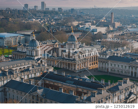 Aerial view of the Old Royal Naval College in Greenwich, London, featuring domed buildings, green spaces, and modern high rises in the background. 125012619