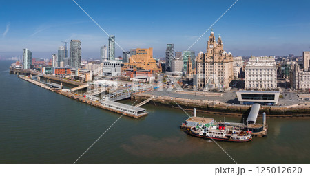 Aerial view of Liverpool showcasing the Royal Liver Building, Port of Liverpool Building, modern skyscrapers, River Mersey, and a docked ferry. 125012620