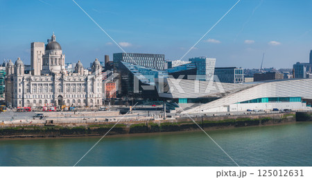 Aerial view of Liverpool showcasing the Port of Liverpool Building, the Museum of Liverpool, modern architecture, and the River Mersey under a clear sky. 125012631