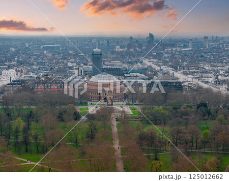 Aerial view of London's Royal Albert Hall with its domed roof, the Albert Memorial, surrounding parkland, and urban architecture under a cloudy sky. Aerial view of London's Royal Albert Hall with its domed roof, the Albert Memorial, surrounding parkland, and urban architecture under a cloudy sky. 125012662
