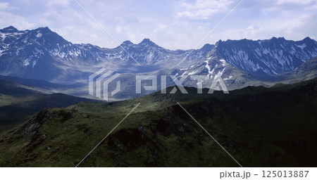 Majestic mountain landscape with snow capped peaks under cloudy sky 125013887