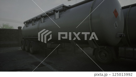 Large gray tanker truck parked in low visibility conditions Large gray tanker truck parked in low visibility conditions 125013992