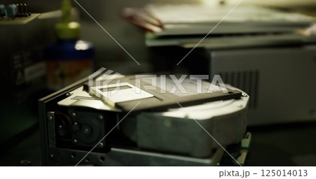 Old technology revival in a workspace showcasing a hard drive and floppy disk 125014013