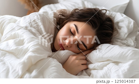 Close up of a Caucasian young woman sweet sleeping on white pillow. The young woman's sweet dreams are captured, her face serene on a soft white pillow. Close up of a Caucasian young woman sweet sleeping on white pillow. The young woman's sweet dreams are captured, her face serene on a soft white pillow. 125014387