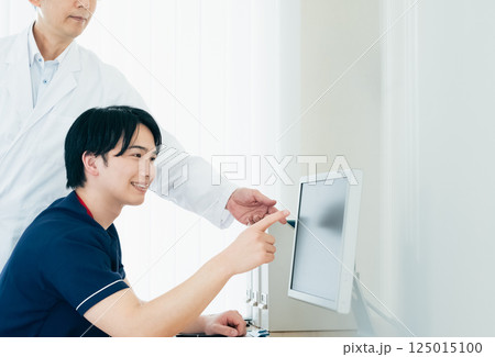 データを見て話し合う男性医師たち 125015100