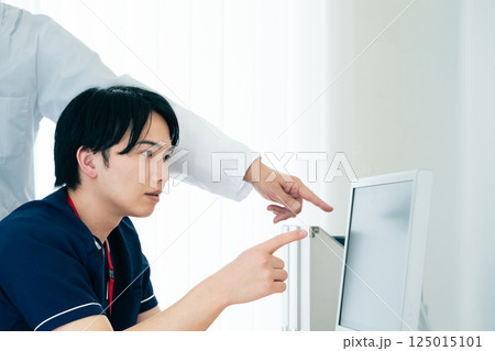 データを見て話し合う男性医師たち データを見て話し合う男性医師たち 125015101