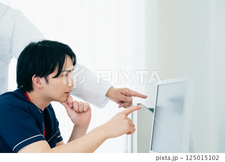 データを見て話し合う男性医師たち データを見て話し合う男性医師たち 125015102