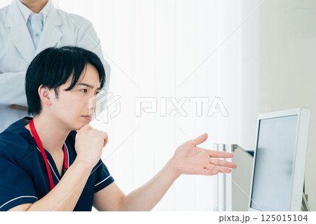 データを見て話し合う男性医師たち 125015104