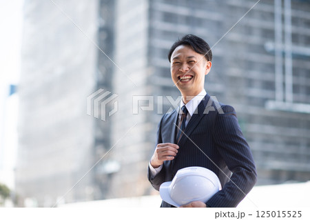 建設現場の外に立つビジネスマン 125015525