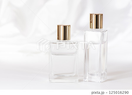 白いサテン布を背景しにたガラス製化粧品ボトル2種 125016290