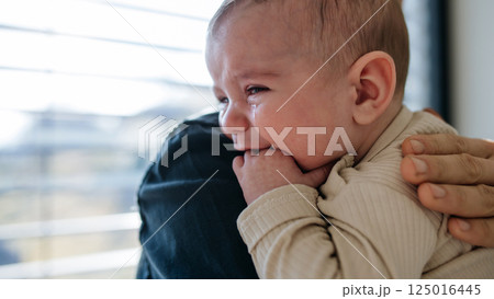 Father comforting his crying baby son. Father comforting his crying baby son. 125016445