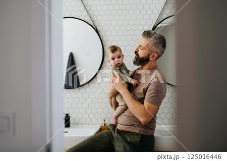 Portrait of father holding baby son in arms. Portrait of father holding baby son in arms. 125016446
