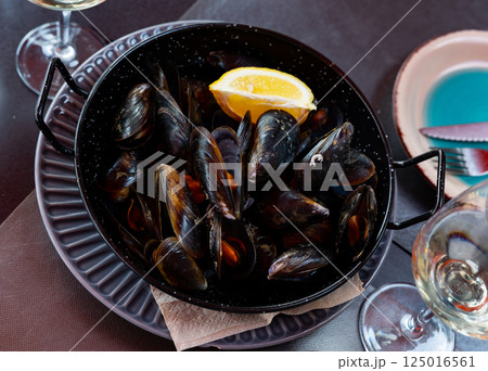 Steamed mussels served on table with piece of lemon Steamed mussels served on table with piece of lemon 125016561