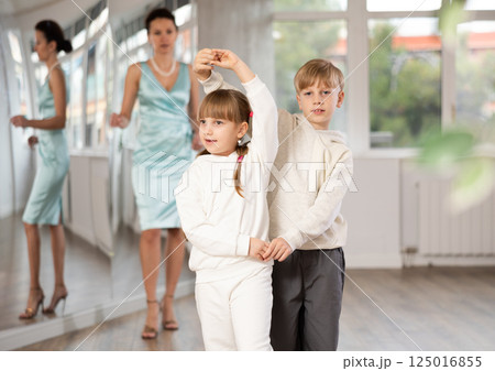 Preteen ballroom dancers practicing elegant dance in pair in studio Preteen ballroom dancers practicing elegant dance in pair in studio 125016855