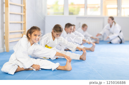 Teacher study children followers perform warm-up exercises and legs stretching Teacher study children followers perform warm-up exercises and legs stretching 125016886