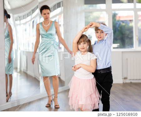 Boy and girl in pair train to dance contemporary vigorous waltz during classes. 125016910