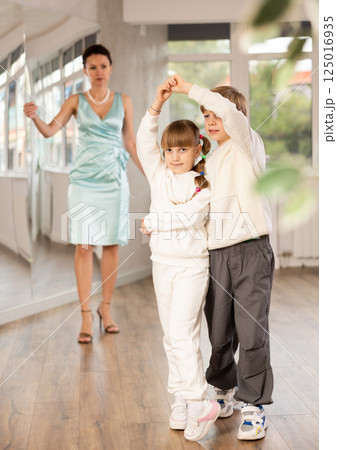 Boy with girl dressed in sport wear train to dance waltz during classes. Boy with girl dressed in sport wear train to dance waltz during classes. 125016935