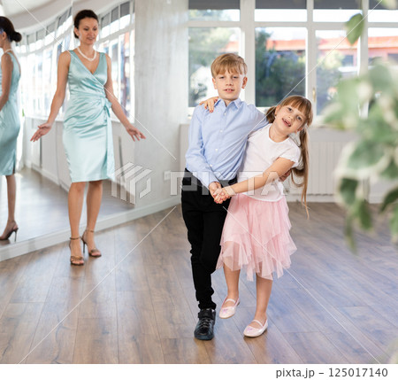Preteen couple practicing swing dance in choreography studio with teacher Preteen couple practicing swing dance in choreography studio with teacher 125017140