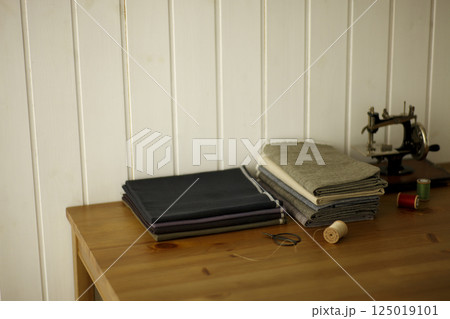 テーブルの上のリネン生地とアンティークミシン 125019101